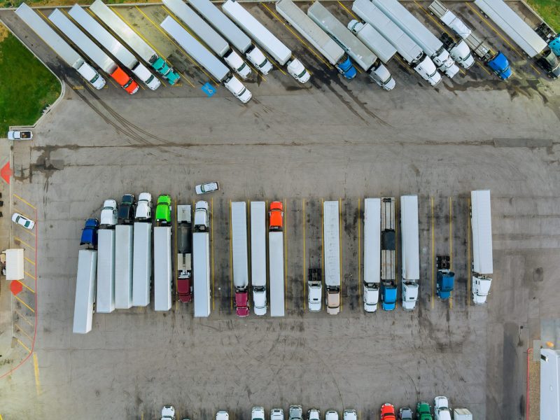 Aerial top view semi truck with cargo trailer car parking of truck rest area dock